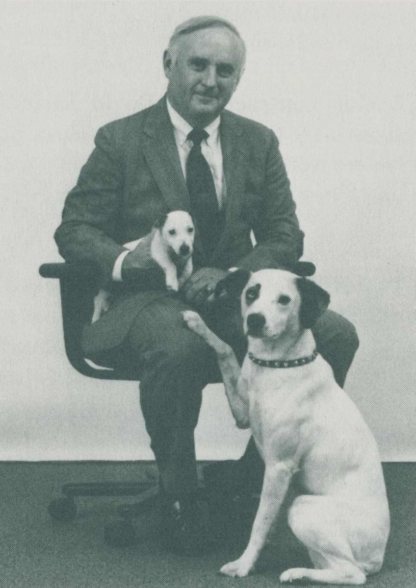 Marty Holleran poses holding the puppy Chipper and next to Nipper the dogo