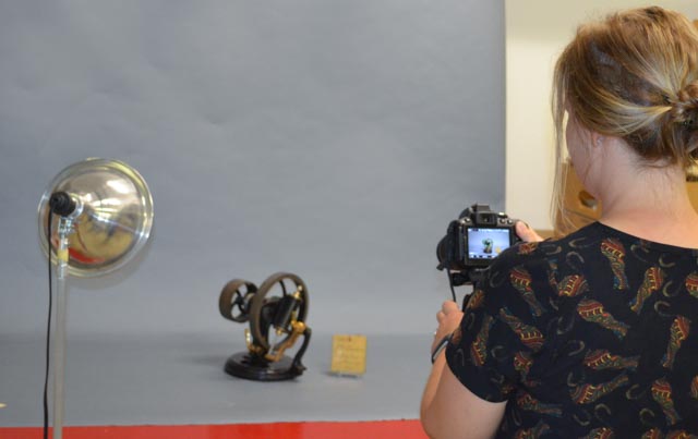 A woman photographs a patent model.