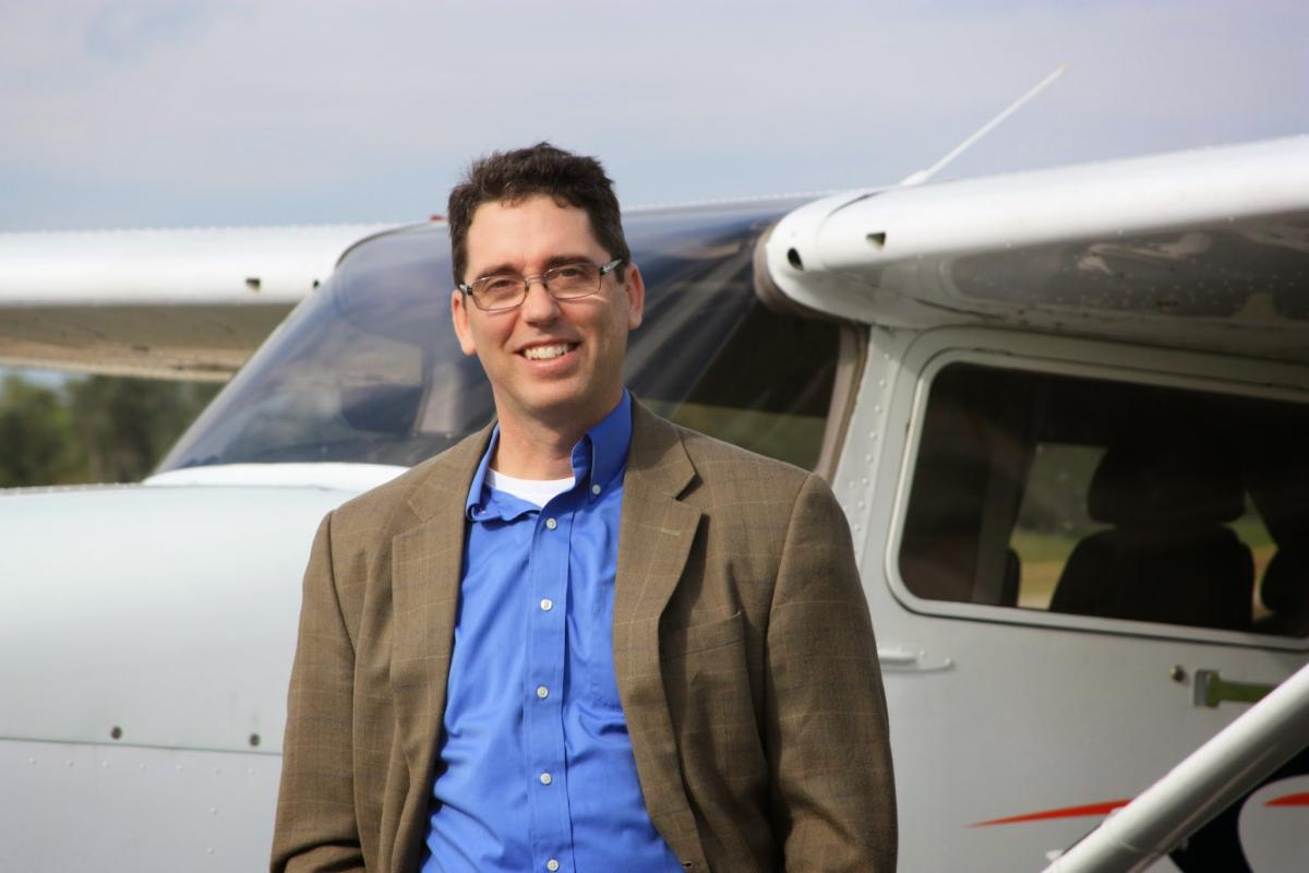 Alan Meyer stands next to a private plane.