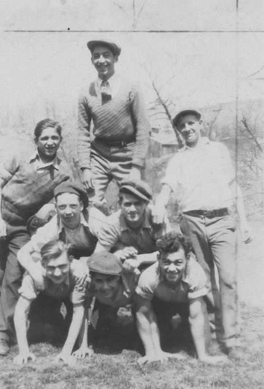 Black and white photograph of eight men forming a human pyramid