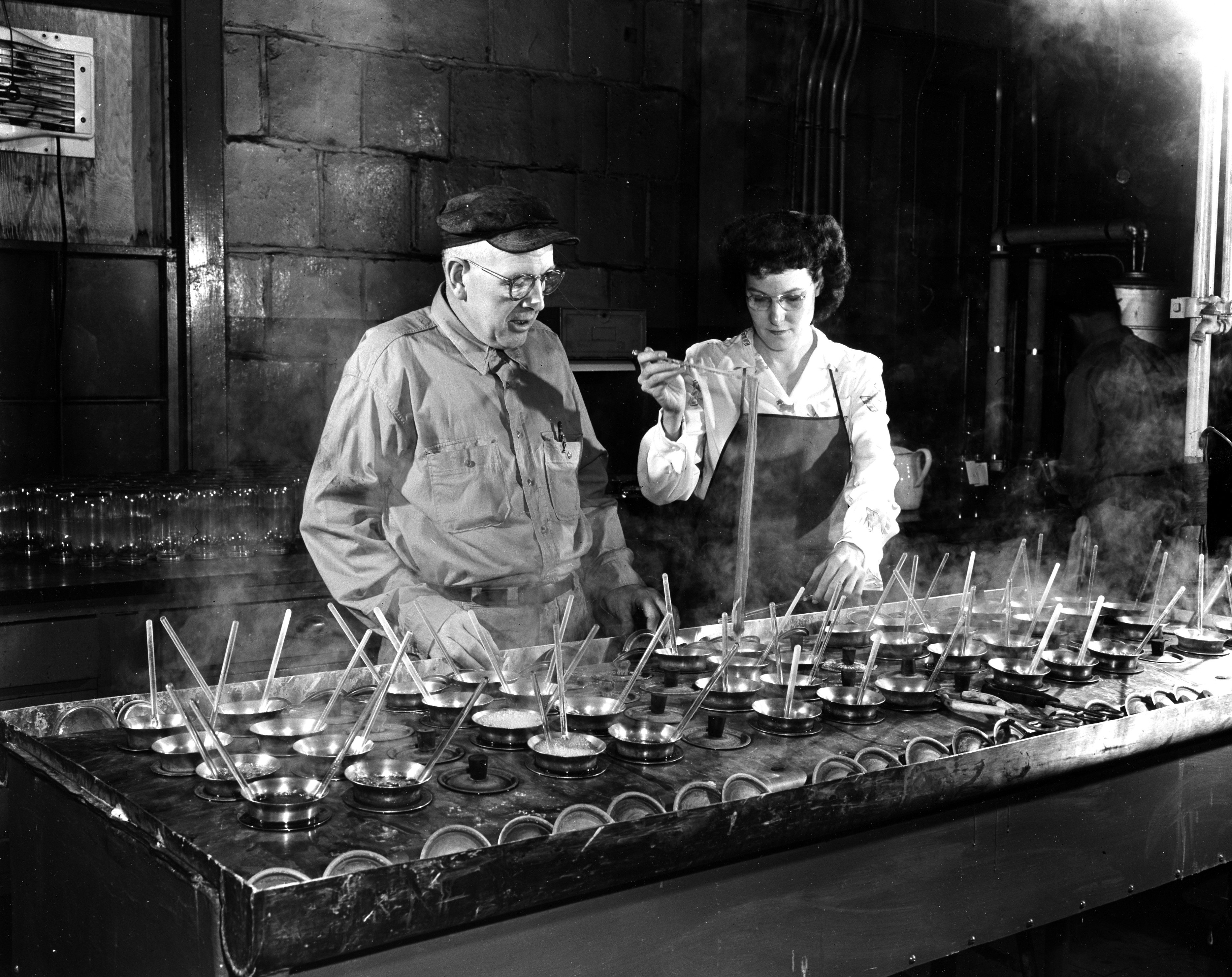 A skilled dye maker at DuPont's Organic Chemicals Department's Chambers Works at Deepwater Point, New Jersey is shown with a lab technician checking dye shades.