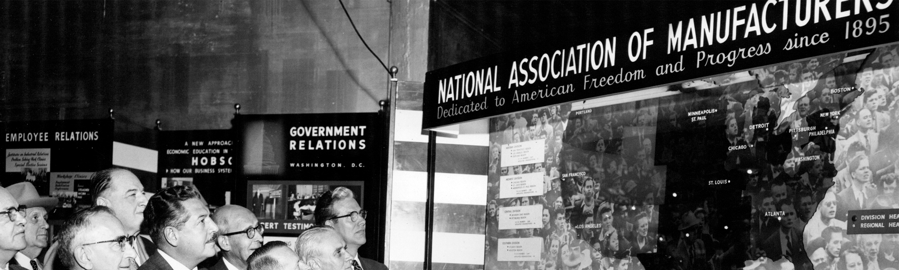 Men look on at an exhibition on manufacturing