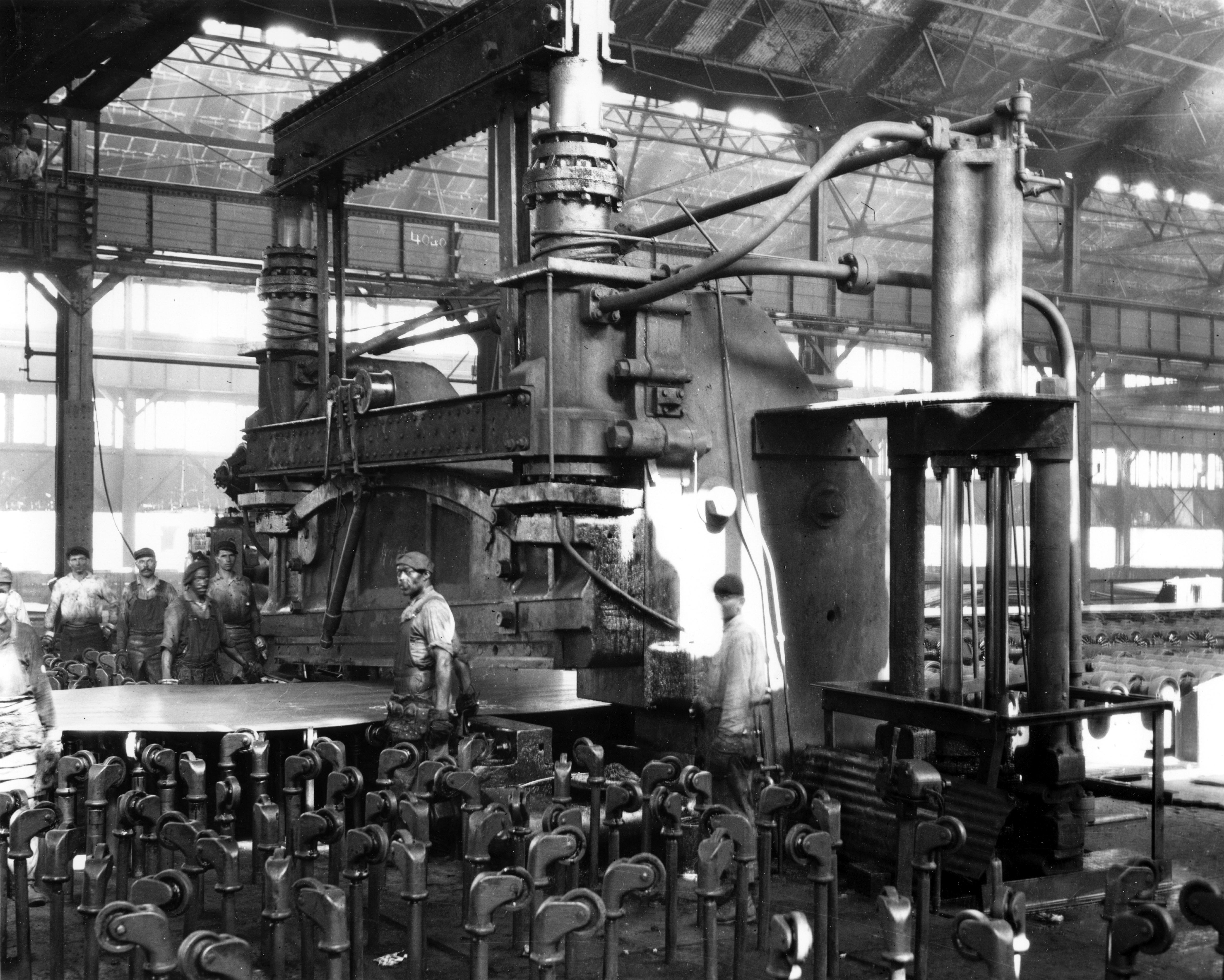 Black and white photograph of steelworkers working around a large piece of equipment.