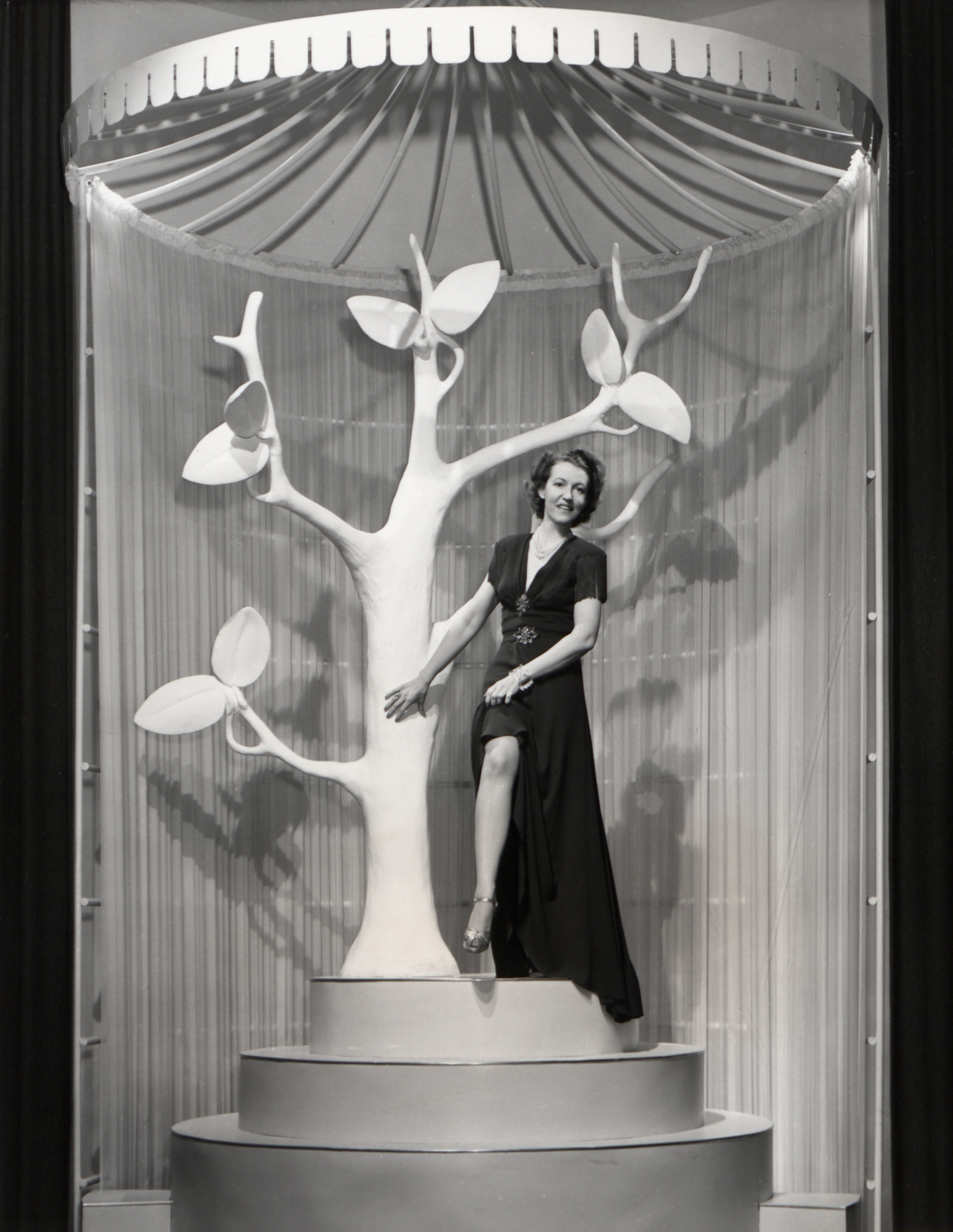 Black and white image of a woman modeling nylon stockings in an exhibit at the New York World's Fair