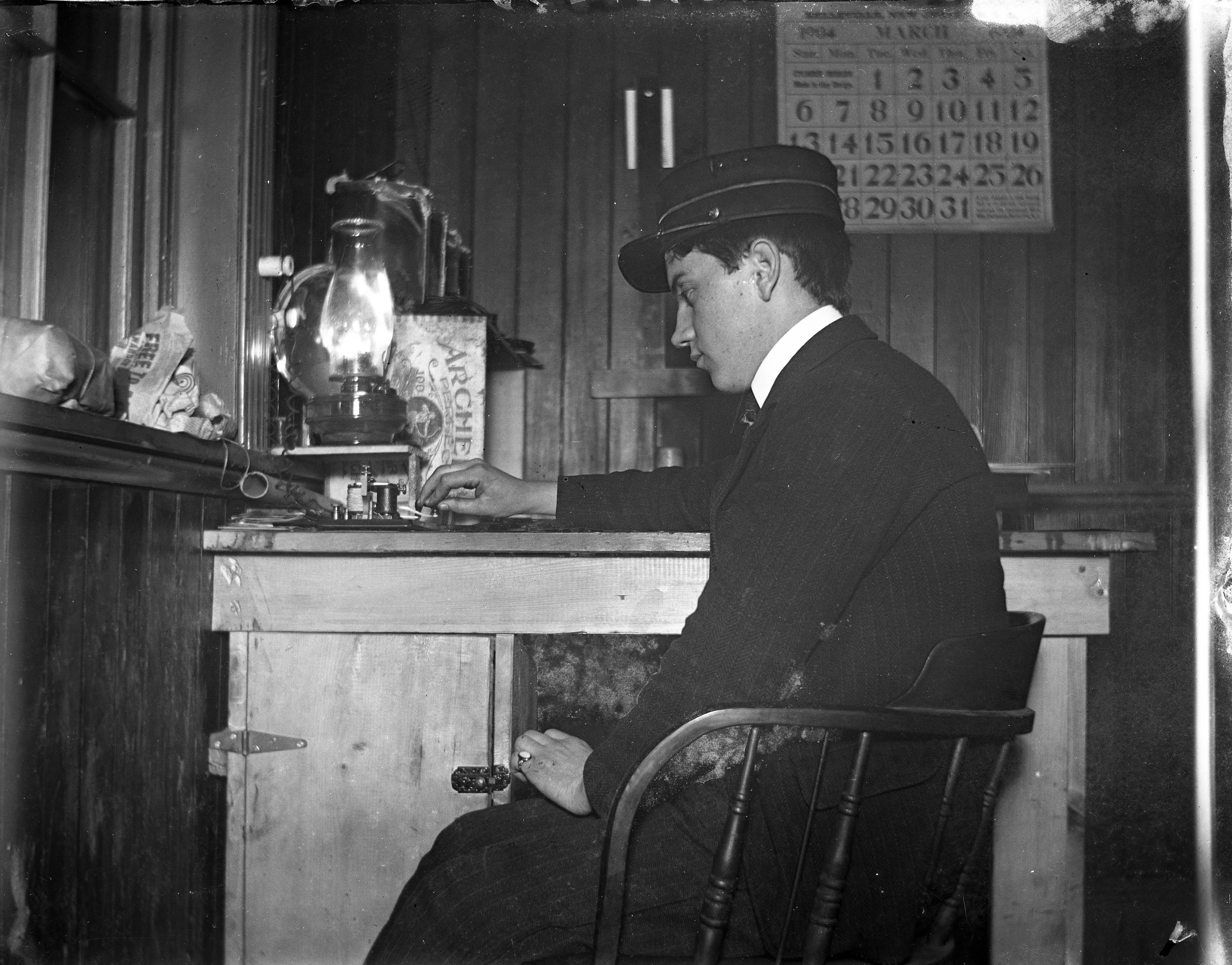 Black and white image of a telegraph operator at work in an office in 1904.