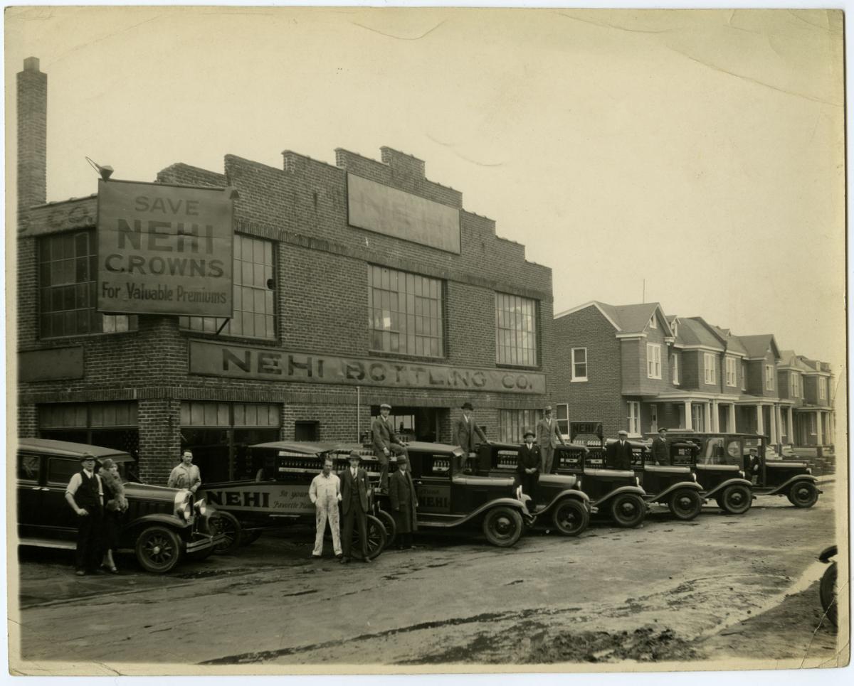 Beer delivery cars and employees stands outside of the brewery warehouse