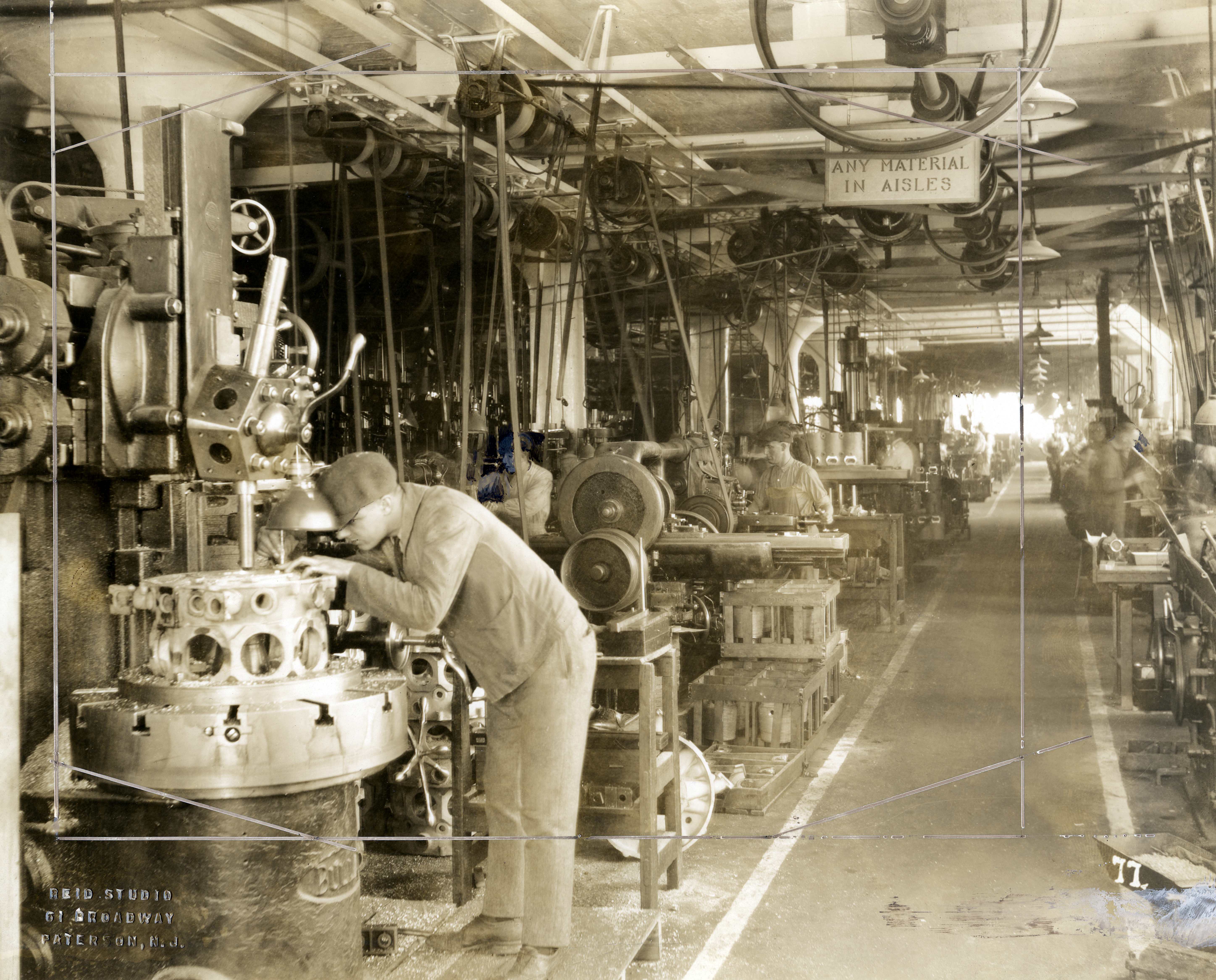 Black and white photograph of a man working in a machine shop.