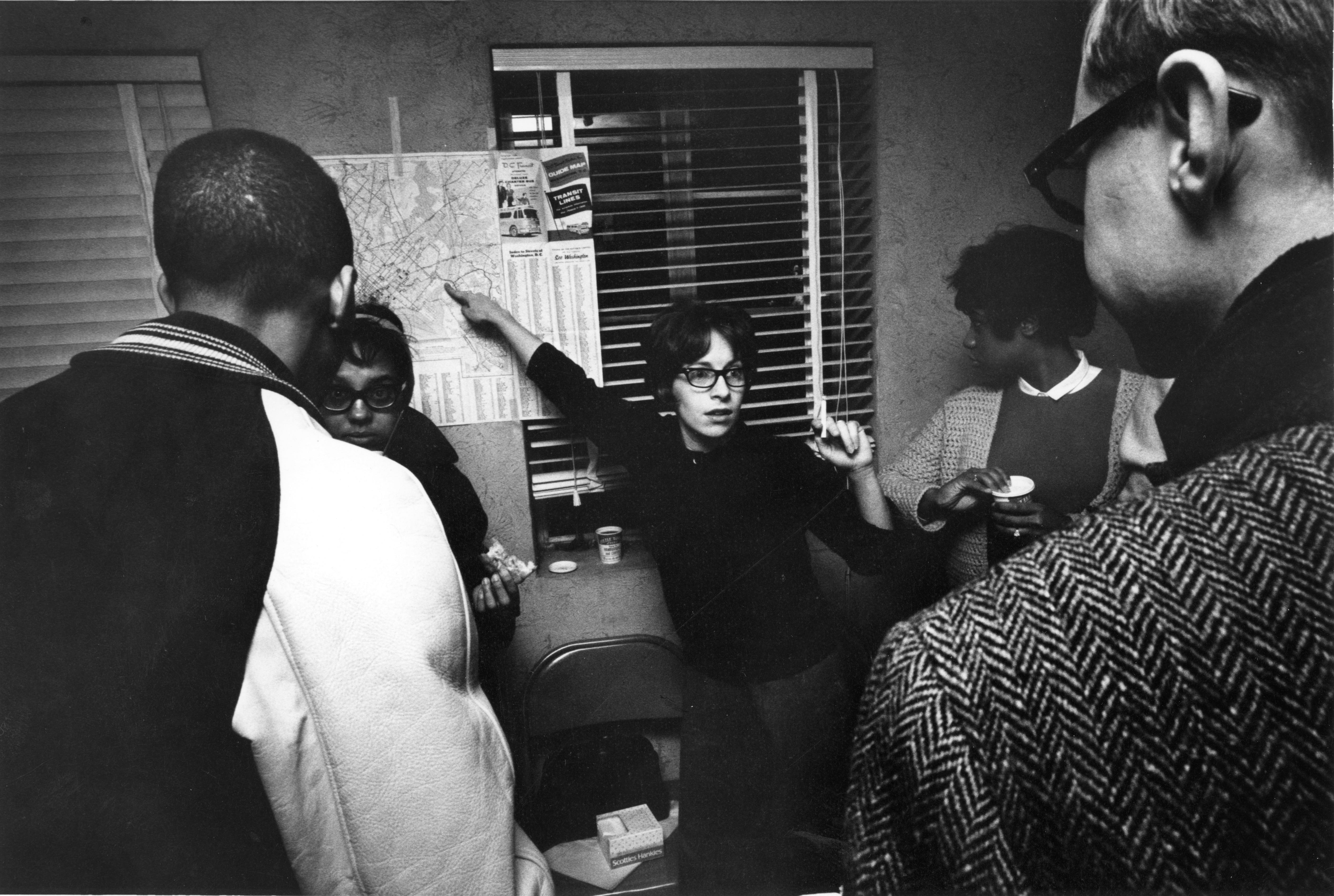 Group of anti-poverty and racial justice activists in an office and consulting a transit map.