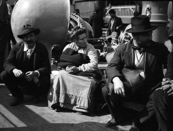 Immigrants seated on ship deck of the Königin Luise