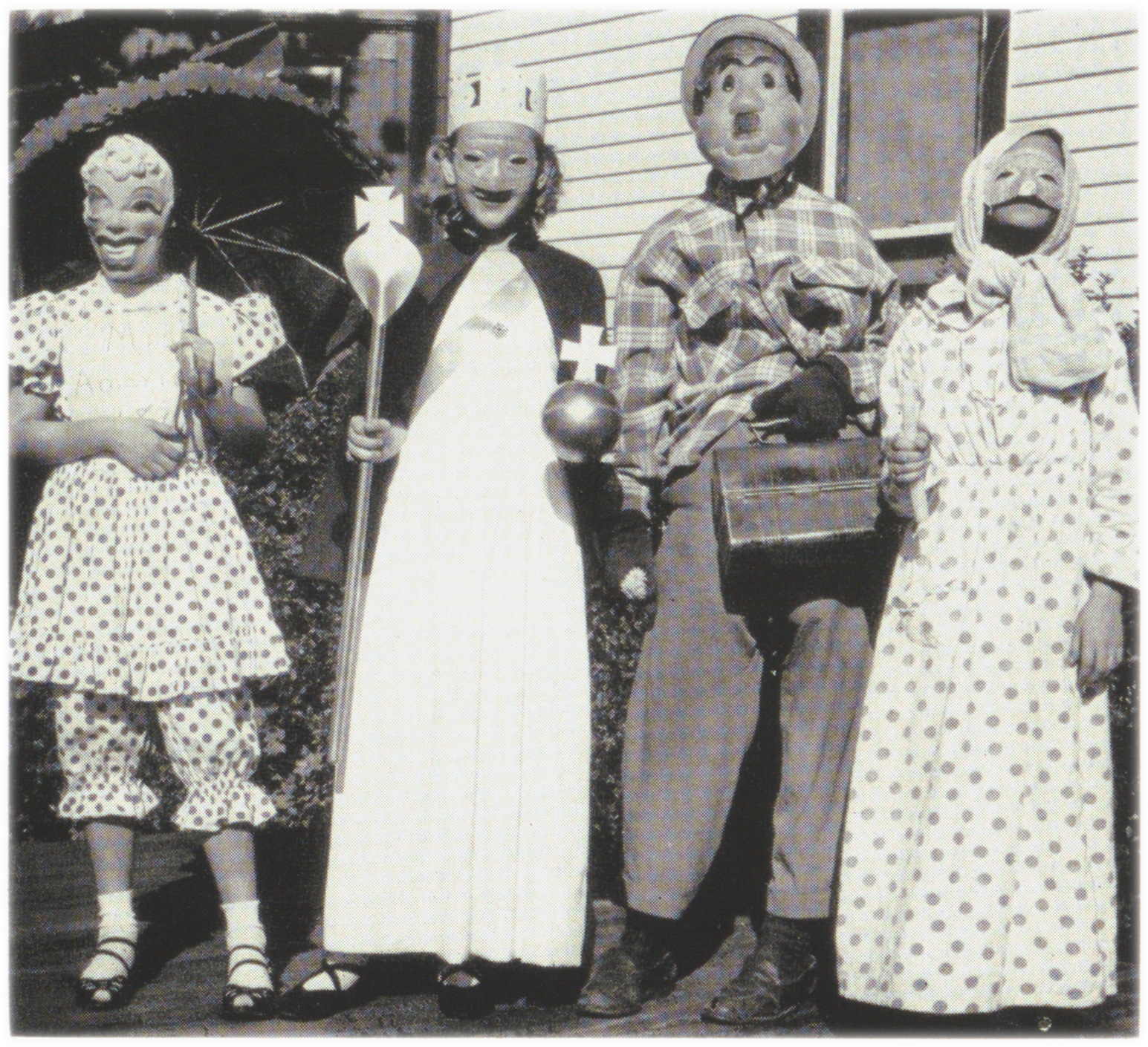 Black and white image of four fifth grade children in 1950s Halloween costumes