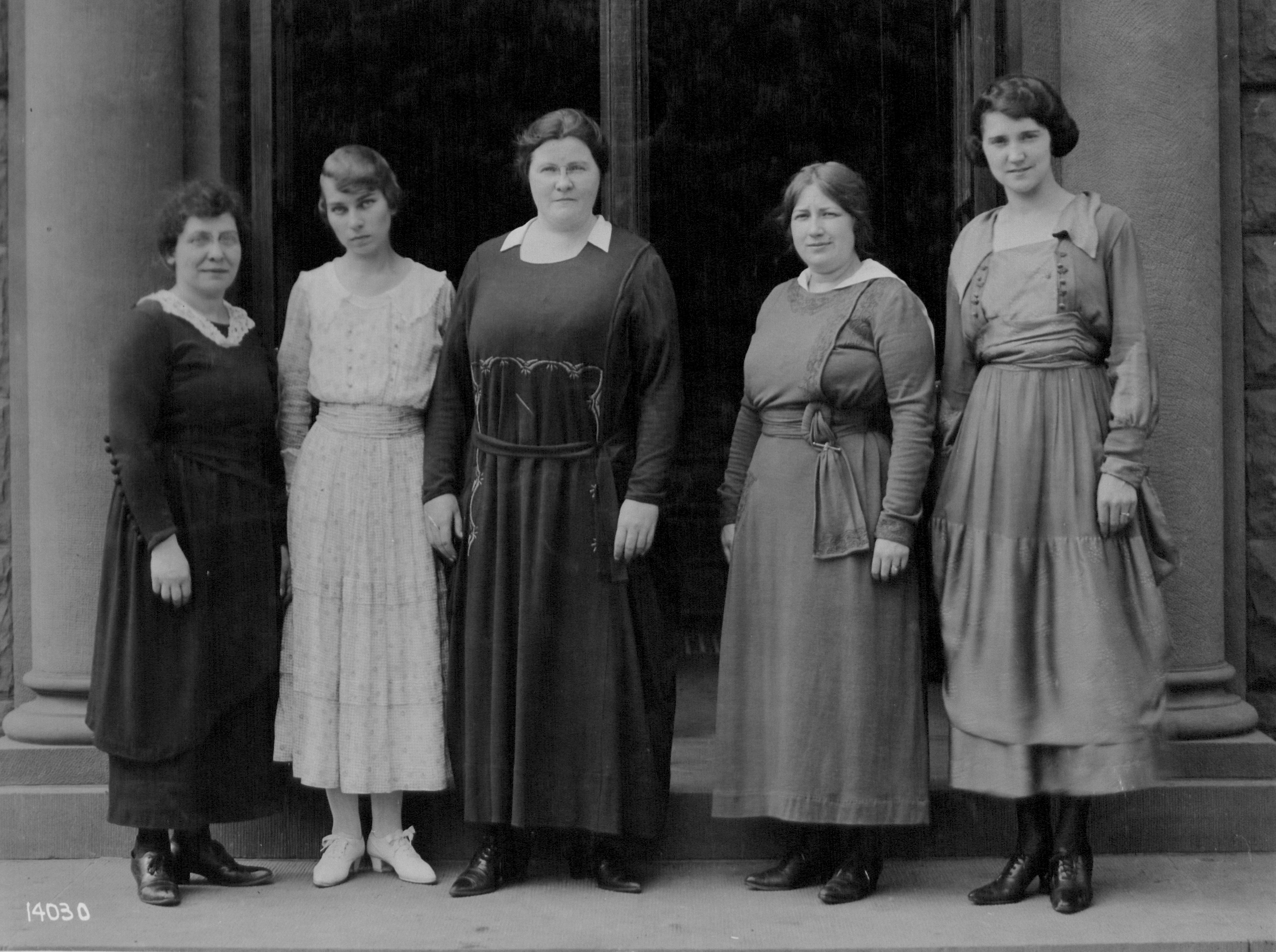 Black and white image of five women on the steps of a school