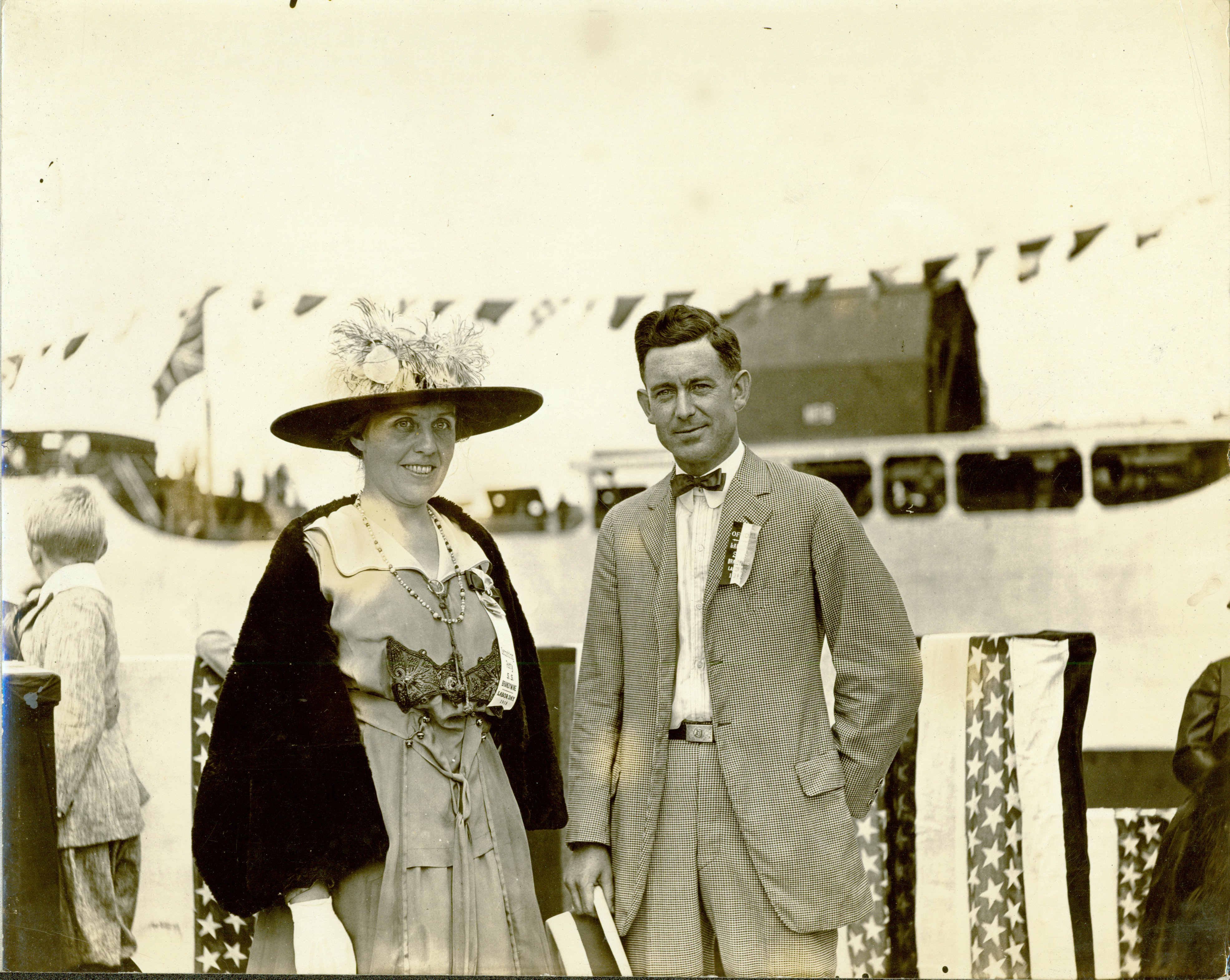 Black and white image of two people attending a ship launching.