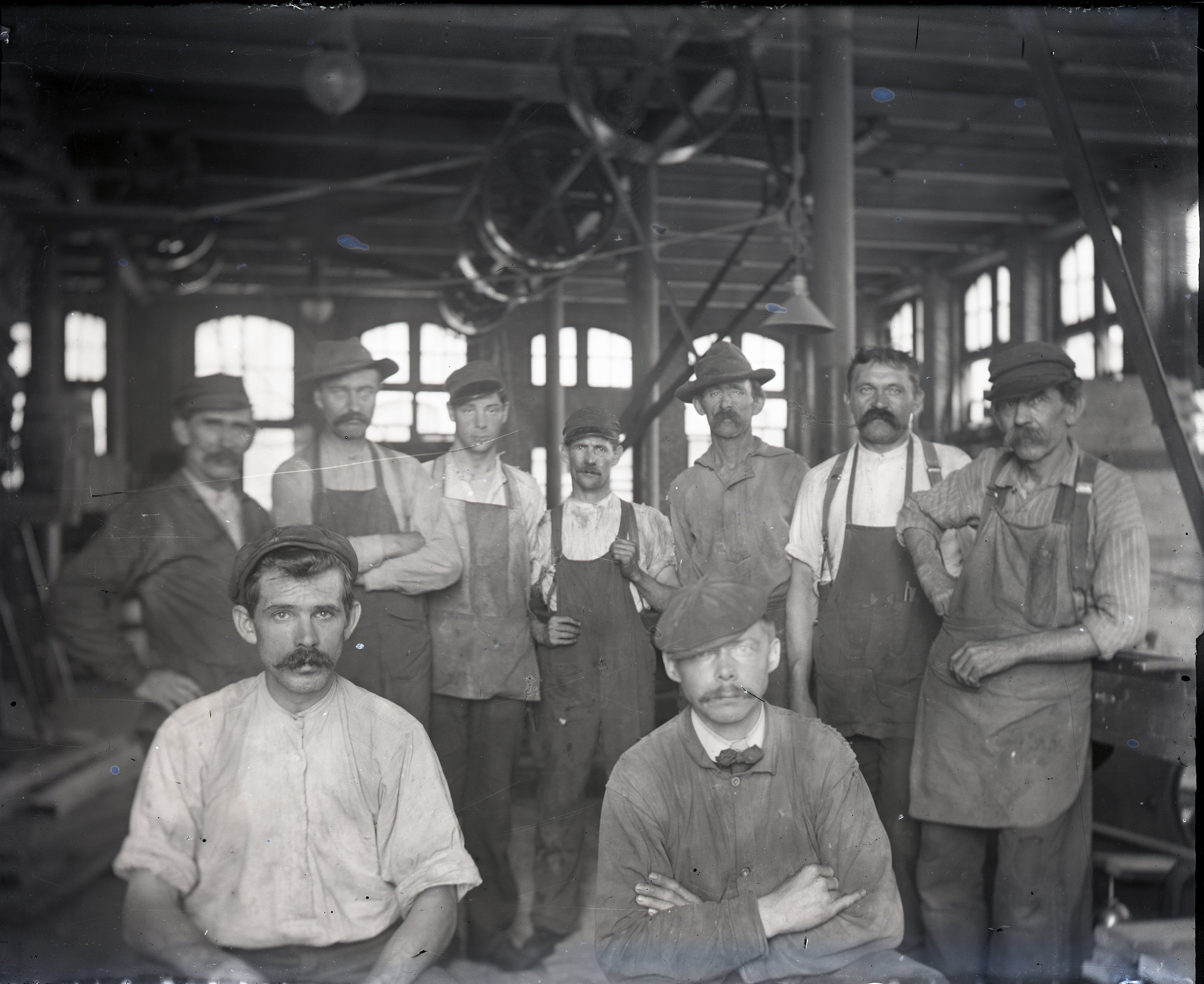 Black and white image of workers posed for a photograph inside a carpenters' shop.