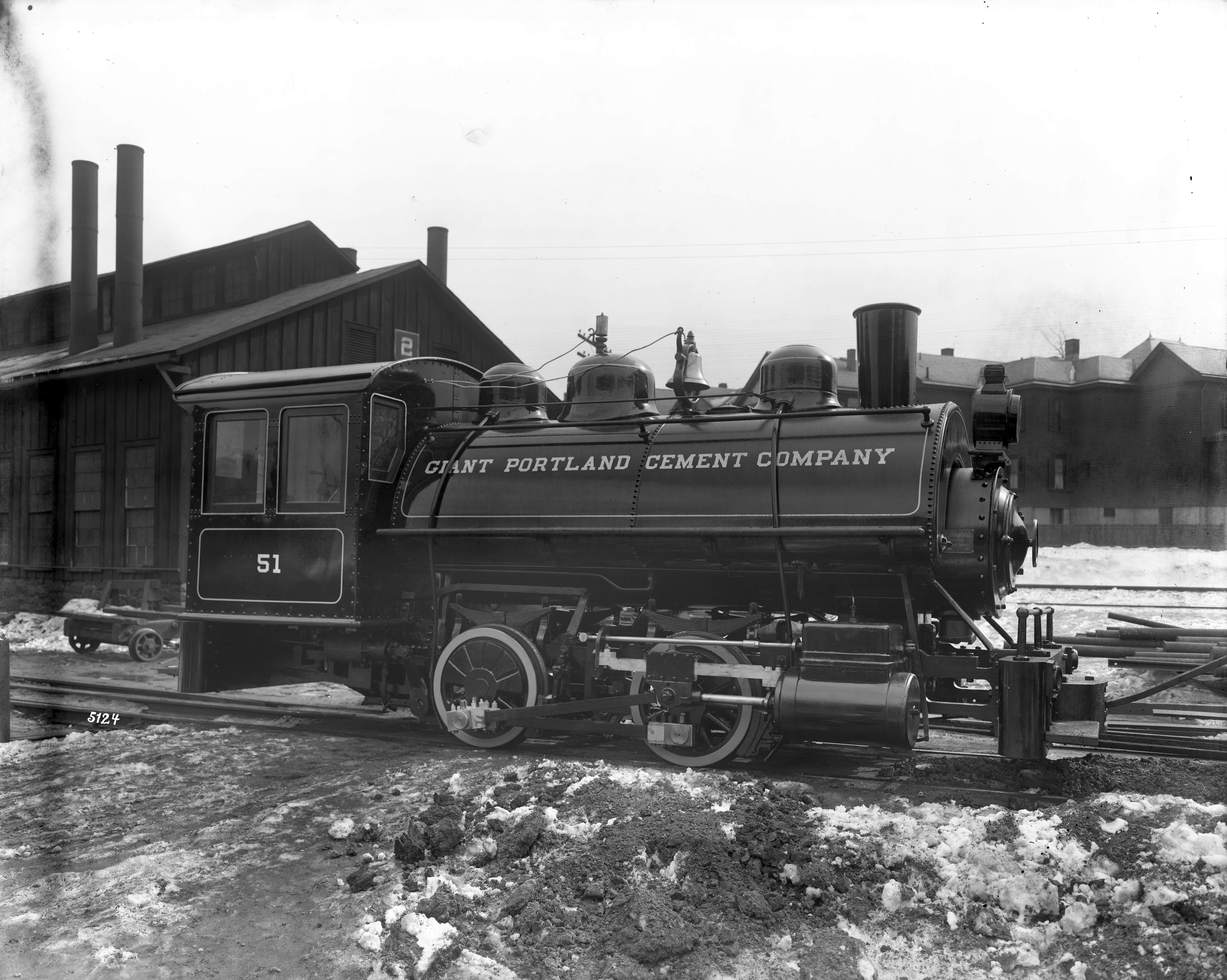 Black and white image of a locomotive in a train yard.