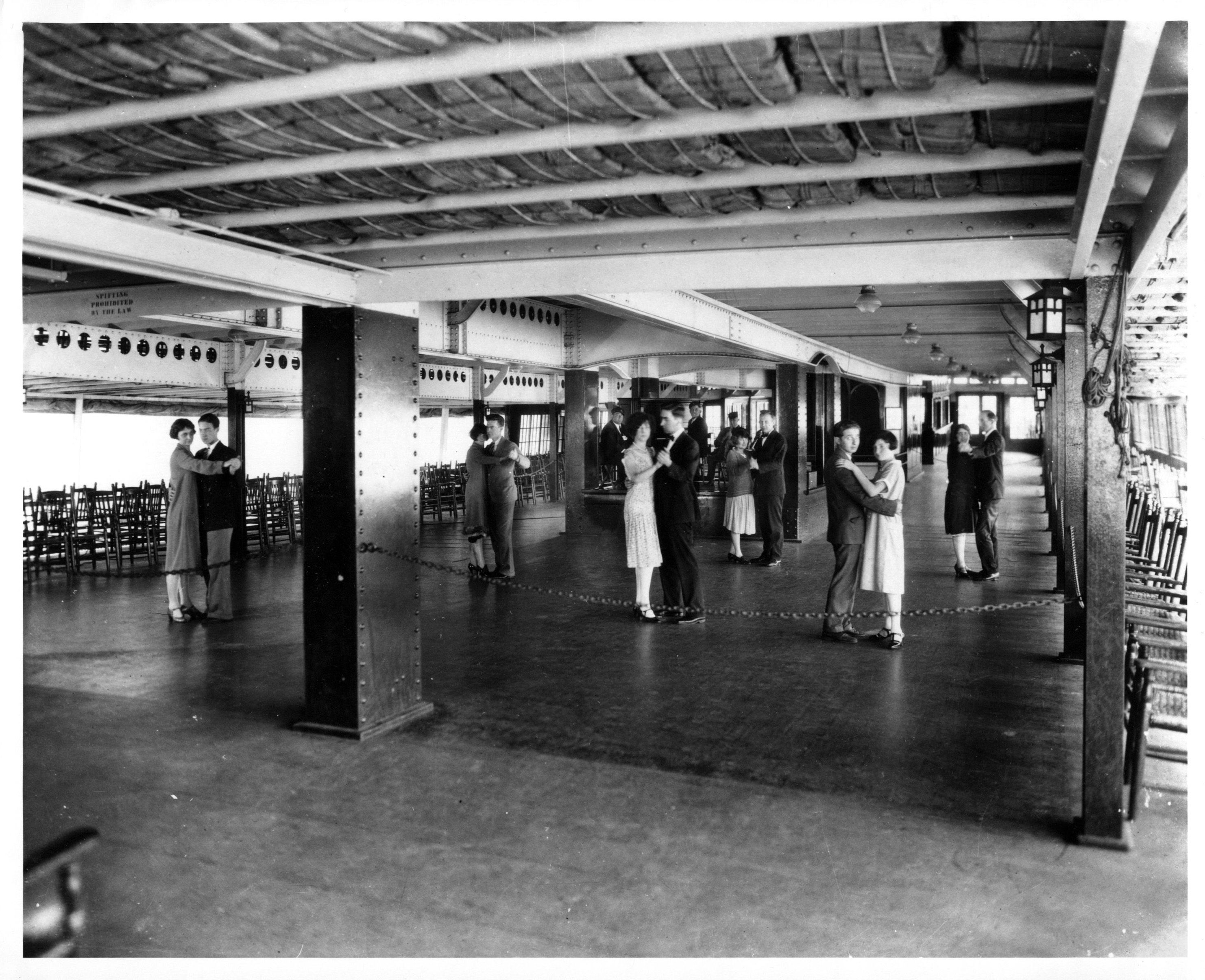 Black and white image of dancers paired off in the ballroom of a ship.