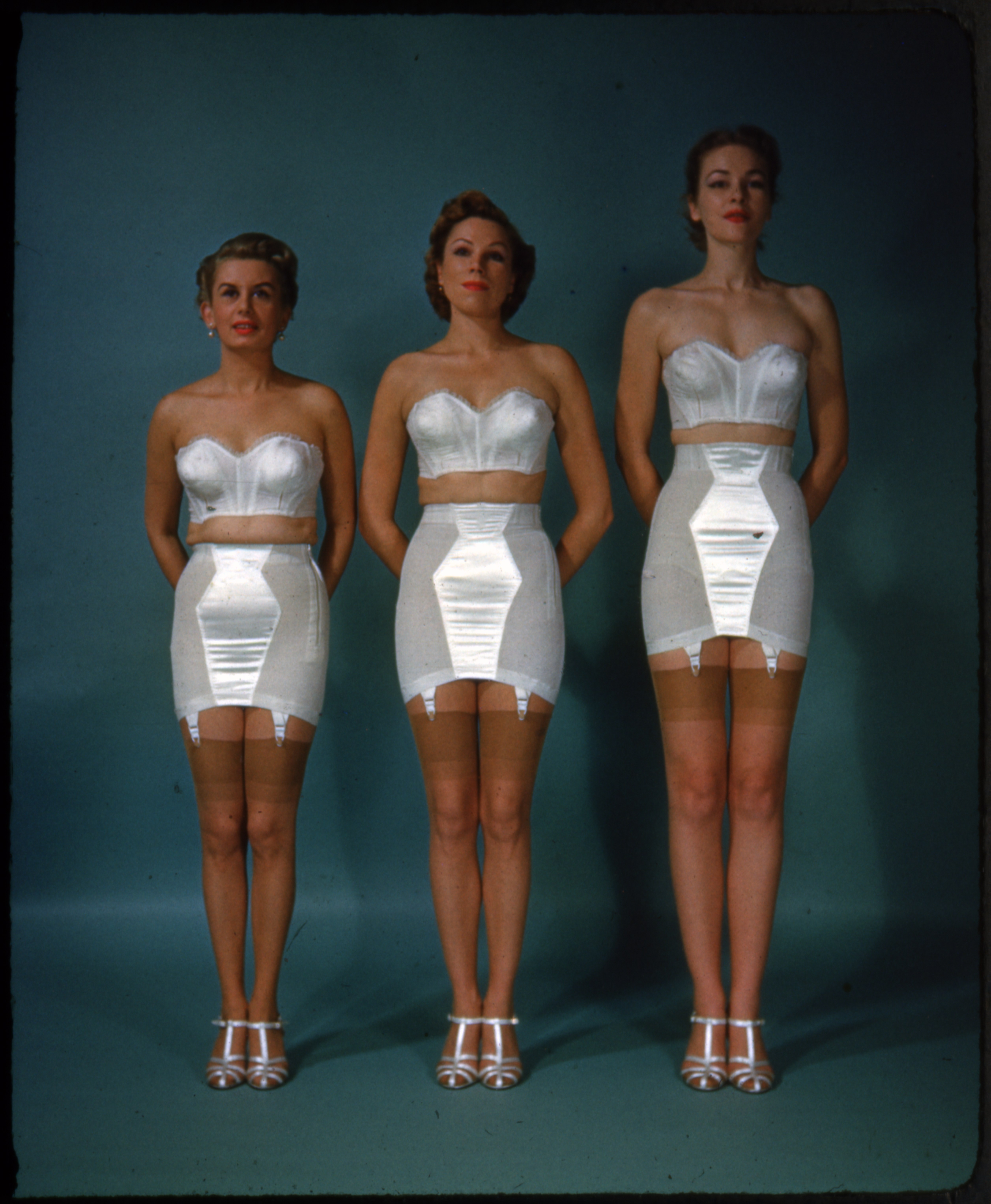 One side of a color stereoview showing three women modeling Hanes proportioned fit undergarments. 