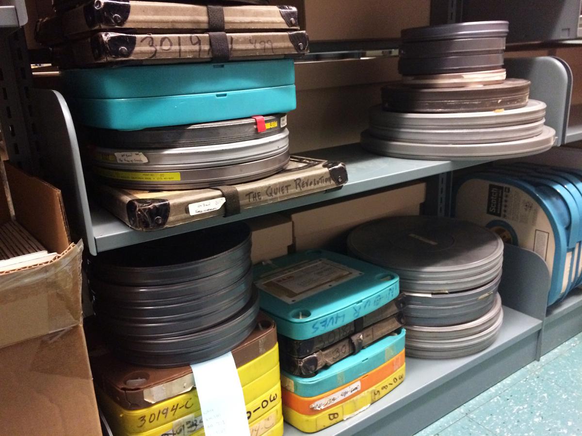 Film canisters and boxes on a metal bookshelf