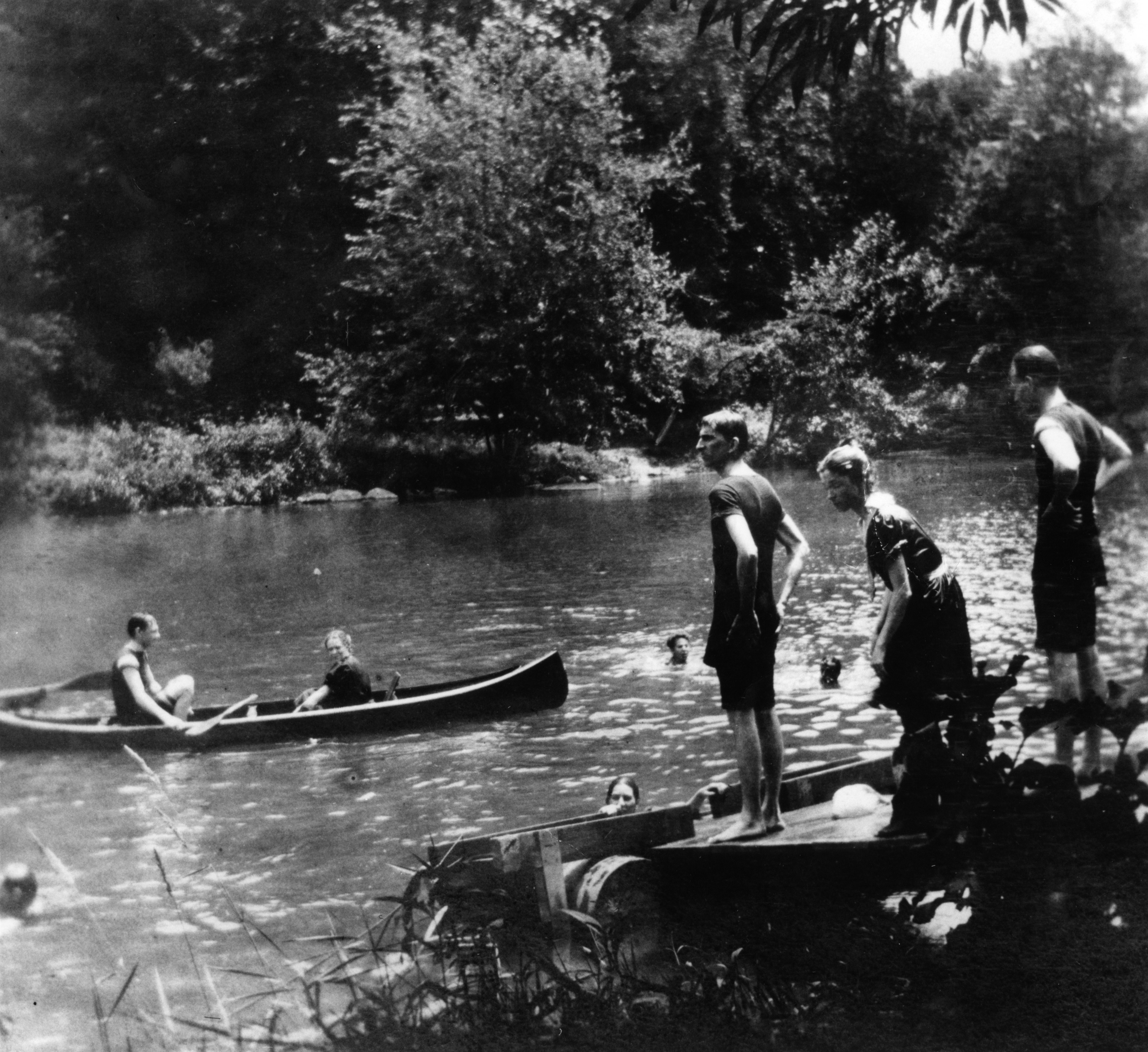 Black and white photograph of people canoeing and swimming in what is probably the Brandywine River.