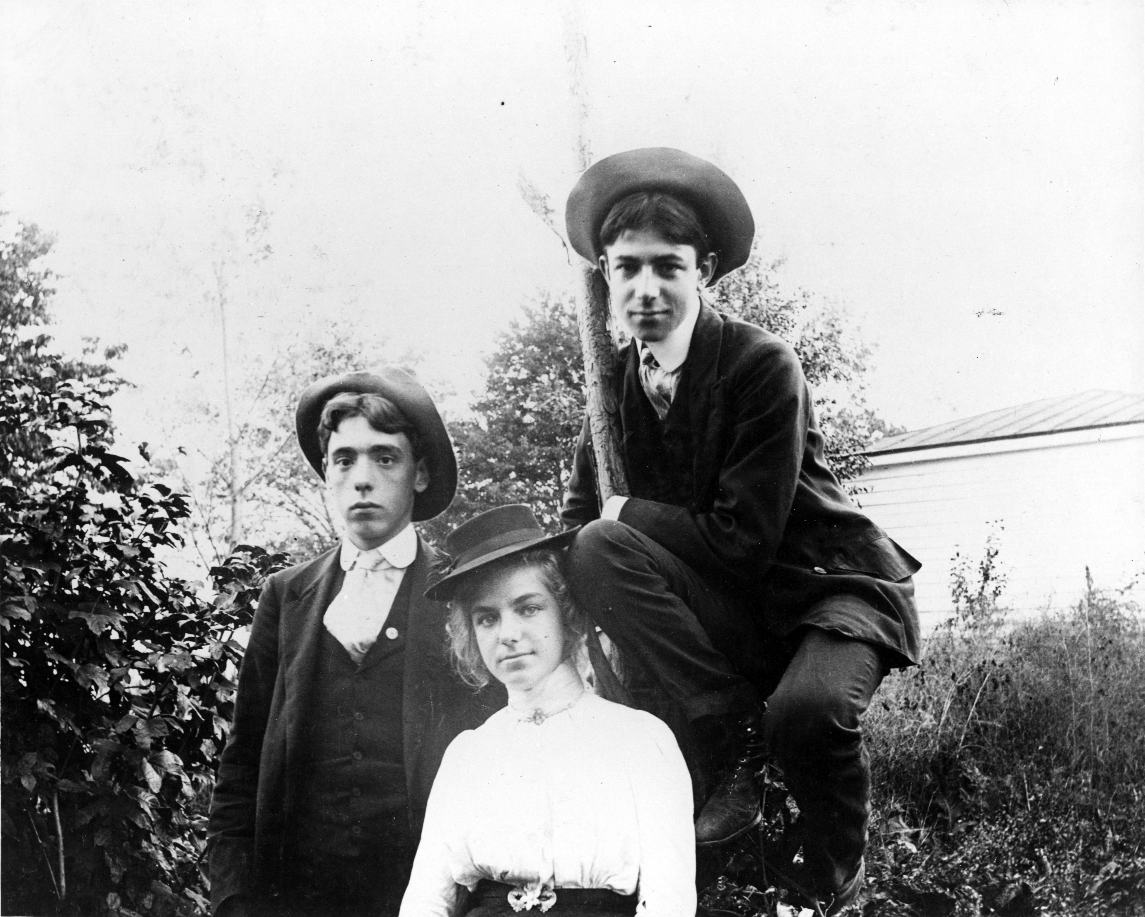 Black and white image of three young people in their late teens; two young men and a woman.