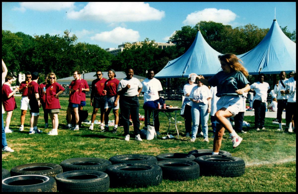 A woman runs through a tire obstacle course.