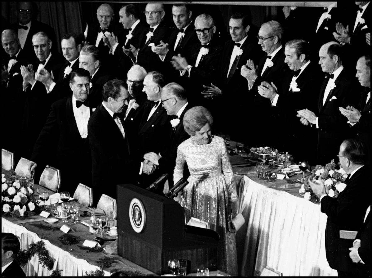 Nixon shakes hands with a NAM member as he receives a standing round of applause.