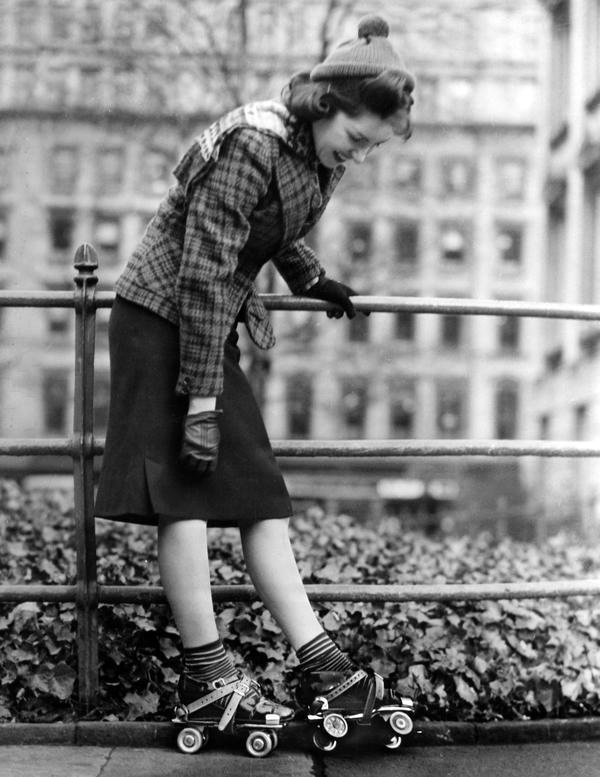 Black and white photograph of a woman wearing roller skates.