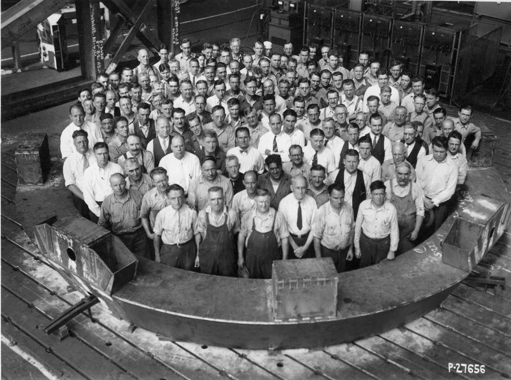 Dozens of employees stand in part of the telescope