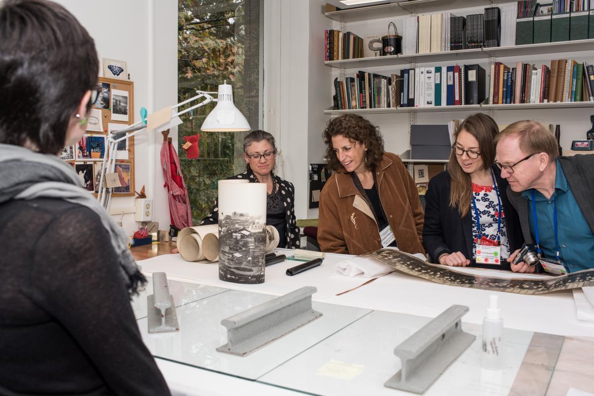 Library conservator Laura Wahl shows the group a panoramic photo being flattened.  Photo by Jackie Kane Photography.