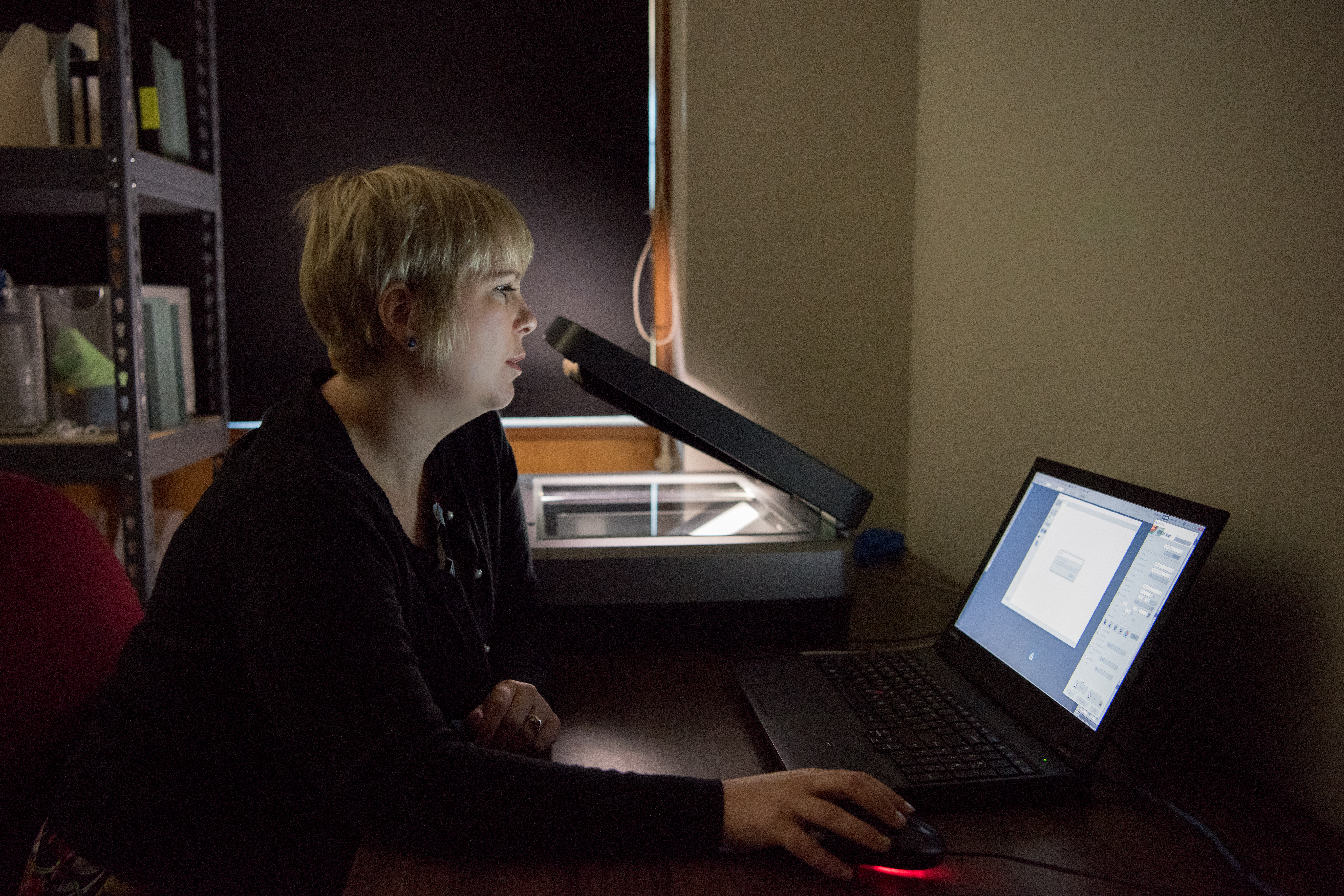 Archivist digitizing images with scanner