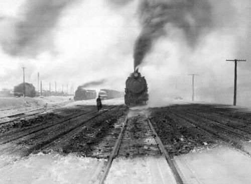 Black and white image of trains in the snow.