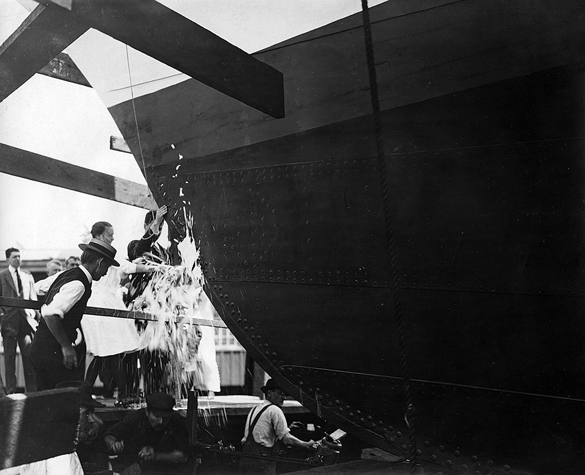 A girl smashes champagne over the yacht's bow