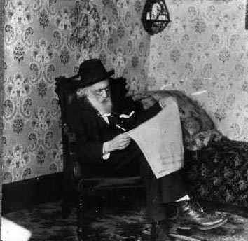 Matthewson reading a newspaper, ca. 1900