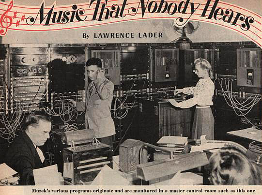 Photo of two men and a woman in a room full of large electronic equipment. 