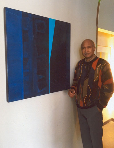 Dr. Wesley Memeger standing next to a canvass of his artwork