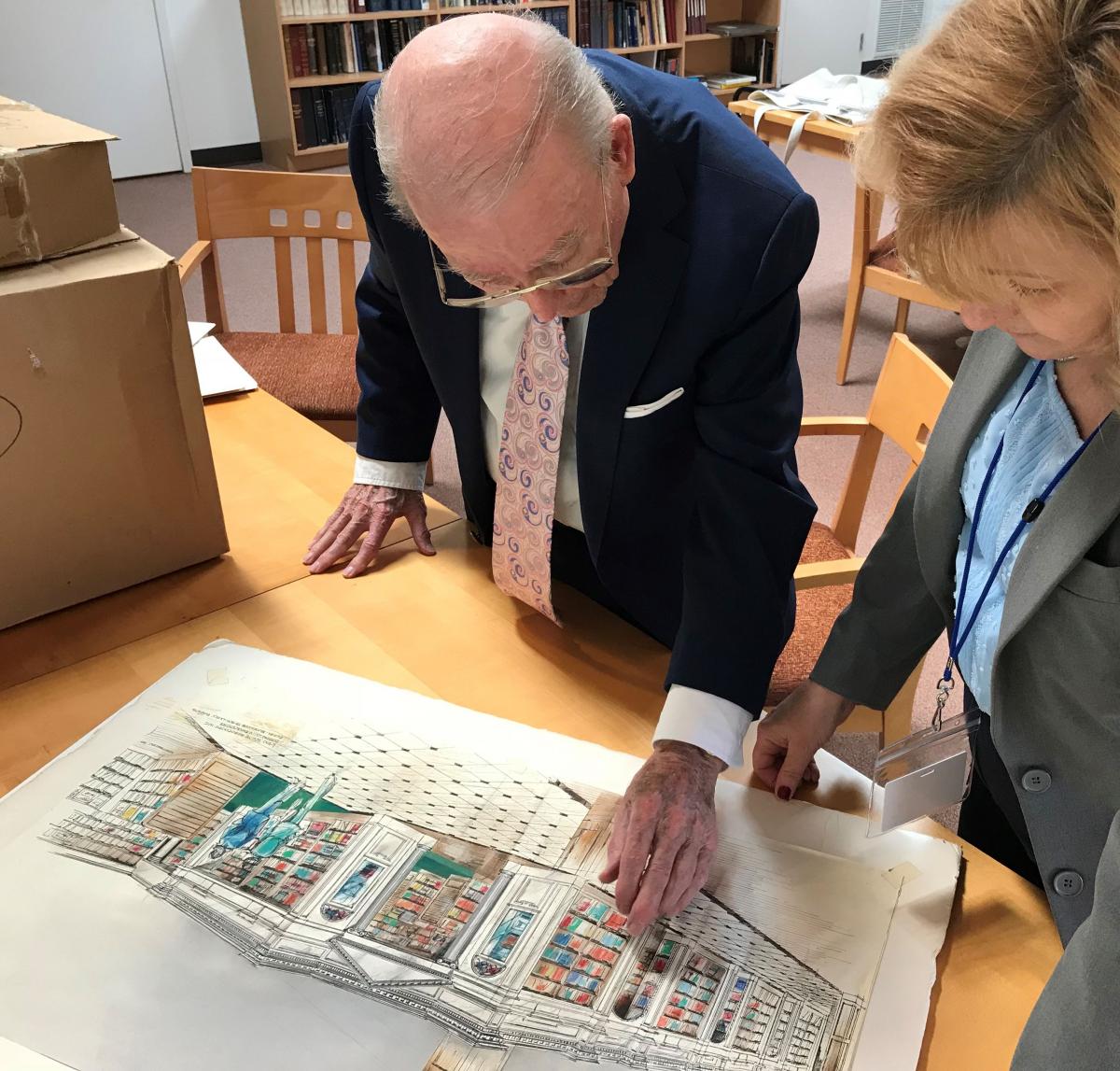 Ken White and Gail looking at one of the watercolor elevations from the Collection.