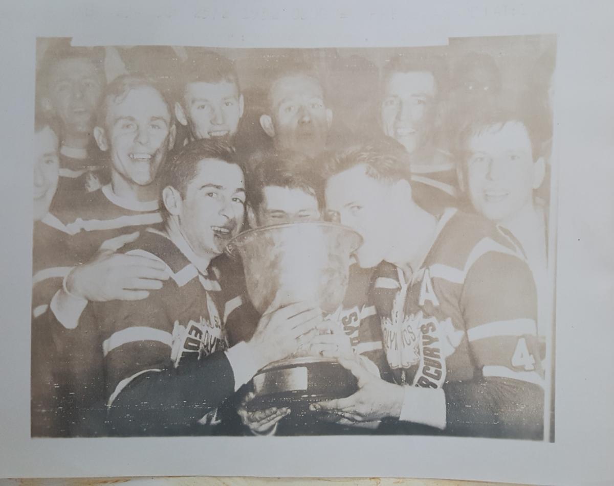A faded photo with a silver cast of a team, probably hockey, holding a trophy