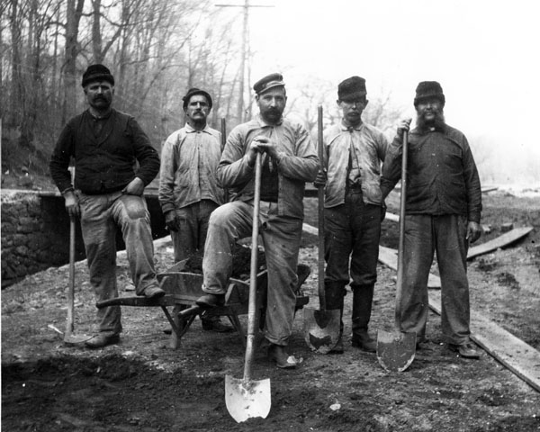 Hagley powder yard workers line up in a photo with some of their tools and shovels