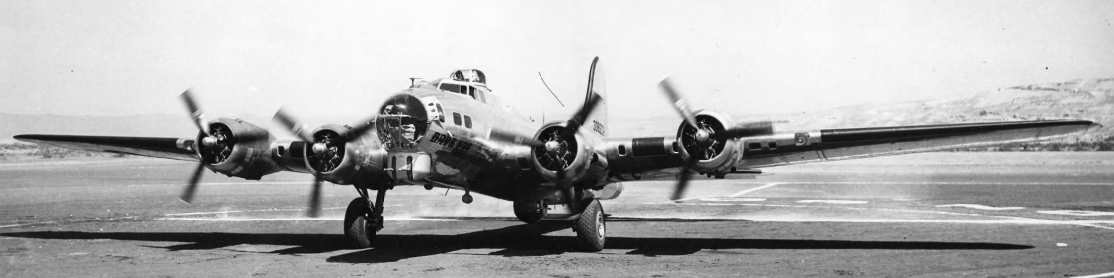 A propellor plane sits on a tarmac in the 1940's.