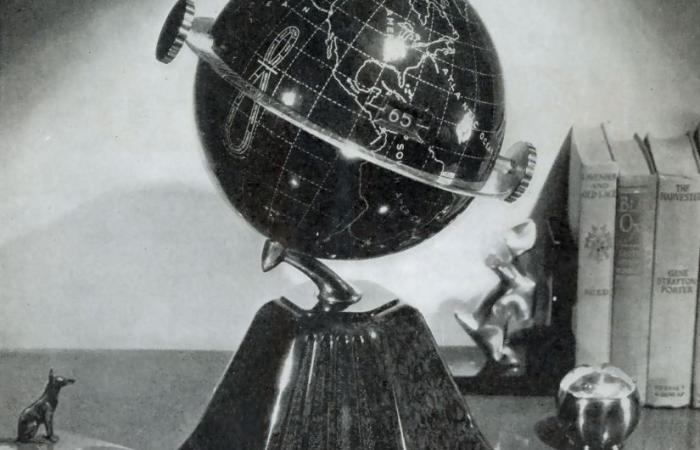 Black and white photo of a globe sitting on a surface.