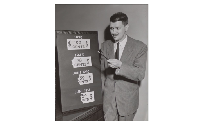 A man with a posterboard from a presentation about financial literacy.