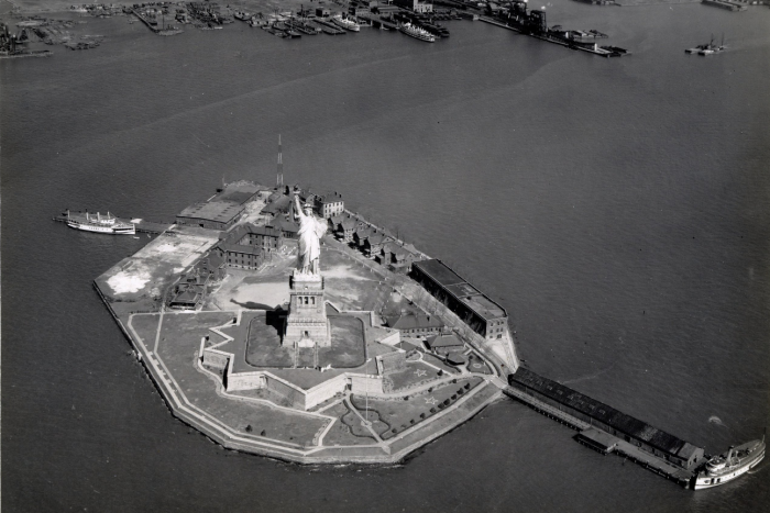 An aerial view of the statue of liberty in black and white.