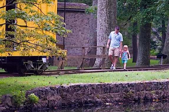 A man and young girl walk at Hagley