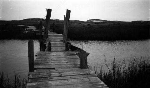 Docked boat on a wooden bridge in a wetlands area of Beach Haven, New Jersey