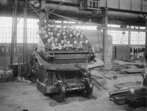 Black and white photograph of a group of workers posed inside a large dredge dipper.