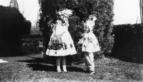 Black and white photograph of two children in Easter costumes with baskets.