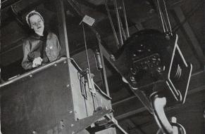 Magazine cover with a black and white photo of a woman operating a crane.
