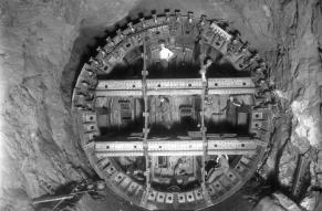 Black and white photograph of workers building a large underground tunnel.