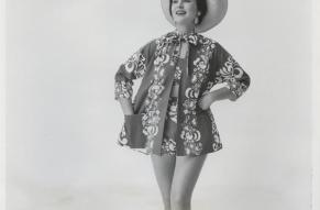 Black and white image of a woman in a beach ensemble with a teal and red color swatch attached.