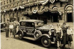 Children and police officers posing with car decorated with anti-Prohibition slogans. 