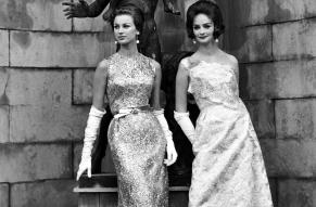 Black and white fashion photograph of two women in glittery evening gowns.